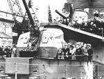 Franklin Roosevelt under USS Cummings’ Number 1 5"/38 caliber gun mount addressing a crowd of shipyard workers at the Puget Sound Naval Shipyard, Bremerton, Washington, United States, 12 Aug 1944.