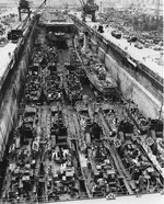 Drydock No. 1 at San Pedro, California, United States, one of the largest drydocks on the west coast, full of ships for upkeep, repair, and conversion, about 14 Jun 1945.