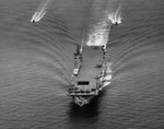 Carrier USS Ticonderoga conducting flight operations during her shakedown cruise while en route Trinidad, 30 Jun 1944. Note landing F6F Hellcat and two Coast Guard escort boats. Photo 2 of 2.