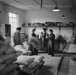 Three WAAF members checking rations while two RAF members unloaded sacks of flour in the store room at the RAF depot at Uxbridge, Middlesex, England, United Kingdom, 1944