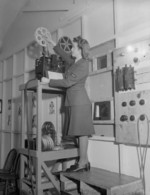 WAAF cine-projectionist preparing a 16mm sound projector, RAF Ford, Sussex, England, United Kingdom, 1940s