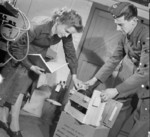 WAAF C. F. Garnet helping an RAF airman unpack a rudder and elevator unit, possibly RAF Bridgnorth, Shropshire, England, United Kingdom, 1942