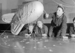 WAAF trainee balloon operators learning their first lesson in tethering a kite balloon with a model at No. 1 Balloon Training Unit, RAF Cardington, Shortstown, Bedfordshire, England, United Kingdom, 1940s