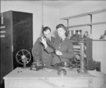 WAAF Sergeant Barrie Monteney examining a spool of film with her RAF commanding officer Squadron Leader E. P. G. Moyna, No. 1 RAFFPU, RAF Stanmore Park, Stanmore, Middlesex, England, United Kingdom, 1940s
