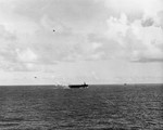 As seen from USS Sangamon off Surigao Island, Philippines, 26 Oct 1944, escort Carrier USS Suwannee recovering aircraft. Note the TBM-1C Avenger lining up to land on the carrier and A6M Zero diving on the ship.