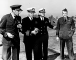 United States Navy Captain Miles Browning, Captain William Harrill, Captain F.B. McCrary, and Vice Admiral William Halsey at Naval Air Station Alameda, California, 6 Sep 1942. Note SNJ Texan aircraft.