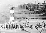 Workers arriving at the CalShip yard by ferry, circa 1944, Los Angeles, California, United States. Note the fourteen CalShip shipways.