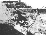 Freighter SS Absaroka in drydock after being torpedoed off San Pedro, California, 24 Dec 1941. This 1942 photo shows the torpedo damage.