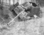 A soldier of US 1st Army posing with a wrecked Jagdtiger tank destroyer, Offensen, Germany, Apr-May 1945