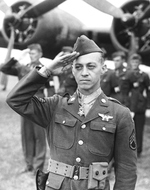 Staff Sergeant Maynard H. Smith of the 306th Bomb Group saluting the colors after being awarded the Medal of Honor at RAF Thurleigh, Bedfordshire, England, United Kingdom, 15 Jul 1943.