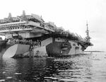 Swimming party alongside escort carrier USS Steamer Bay, late 1944-early 1945, location unknown. Note the Measure 32, Design 12A camouflage and the TBM Avengers on the flight deck.