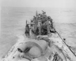 Wrecked Mikazuki being inspected by USMC personnel, off Cape Gloucester, New Britain, 8 Feb 1944; note 4.7-inch gun and nearby bomb hole, viewed from searchlight platform