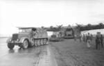 A SdKfz 8 halftrack vehicle and a Praga T-9 vehicle pulling a Me 323 Gigant aircraft, Tunisia, Dec 1942