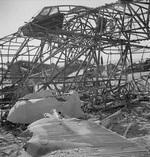 Wing of a Ju 52/3m aircraft (foreground), wreck of a Me 323 Gigant aircraft (center), damaged Hs 129B aircraft (behind Me 323), and damaged Fw 190A-4 aircraft (right edge of background) at El Aouiana Airfield, Tunis, Tunisia, May 1943