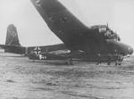 Bf 108B Taifun (foreground) and Me 323 Gigant (background) aircraft at rest, 1940s