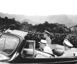 While touring Oahu, US Territory of Hawaii, President Franklin Roosevelt (seated in car) listened to Col William Saffarans (in jungle suit) at the Army’s Jungle Training Unit at Kahana Bay, 28 July 1944. Photo 2 of 2.