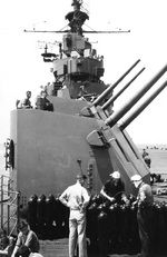 Ordnancemen aboard USS Yorktown (Essex-class) setting bomb fuses on the flight deck just forward of No. 1 5-inch/38 twin gun mount, circa Oct 1943. Note sighting hood covers open on the gun mounts.