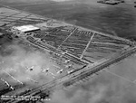 Seven Navy biplanes flying in formation above Mines Field, Inglewood, California during the 1928 National Air Races, 15 Sep 1928. Note the hundreds of parked cars in the field.