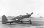 A-36A Mustang aircraft #42-83663, probably at North American Aviation plant at Inglewood, California, United States, 1942; note barrage balloons and two possible SBD Dauntless in right background