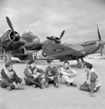 British pilots resting at Luqa airfield, Malta,  Jan 1943; note Beaufighter and Spitfire Mk VC aircraft in background