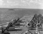 SB2C-5 Helldiver and F4U Corsair aircraft of US Navy squadrons VB-89 and VF-89 aboard USS Antietam, 1945; note USS Higbee in background