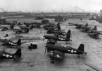 F4U-1 Corsair, FM-2 Wildcat, SNC-1 Falcon, and Culver TD2C aircraft at Naval Air Station Long Beach, California, United States, 10 Aug 1944; note SB2C Helldiver aircraft in background behind pile