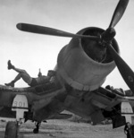 Men of US Marine Corps squadron VMF-222 resting on the wing of a F4U-1 Corsair fighter, Bougainville, Solomon Islands, Apr 1944