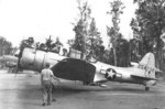 RA-24B-15-DT Banshee aircraft (serial number 42-54736) preparing for take off on Morotai in the Moluccas, 1 Jan 1945; note C-47 Skytrain and hulk of C-45 Expeditor fuselage