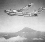 A formation of G4M1 Model 11 bombers in flight with a mountain in the background, date unknown