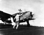 Flight deck officer of USS Hancock directing a SB2C Helldiver aircraft for takeoff, off Philippine Islands, 25 Nov 1944