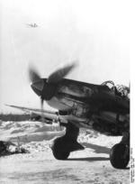 German Ju 87D Stuka dive bomber on the ground in Russia, Mar 1942; note Ju 52 aircraft in flight above