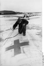 German aircraft being sprayed with white paint for winter camouflage, Eastern Europe, Dec 1943; note Ju 87 Stuka dive bomber in background