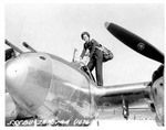 WASP pilot Ruth Dailey climbing into a P-38 Lightning aircraft, 28 Nov 1944