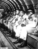 16 US Army African-American paratrooper trainees in a C-47 Skytrain aircraft, preparing to make 1 of the 5 qualifying jumps, Fort Benning, Georgia, United States, Mar 1944