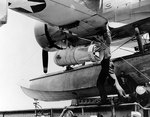 Removing a Mark XVII depth bomb from SOC Seagull aircraft of cruiser Philadelphia, 2 Jul 1942, photo 1 of 2