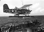 SOC Seagull aircraft being lowered onto catapult of cruiser Minneapolis, after spotting for the Wake Island raid of 5 Oct 1943