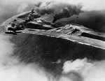 SOC aircraft flew over Wotje Atoll, Marshall Islands, during attack on Japanese airfields by gunfire from cruisers Salt Lake City and Northampton, 1 Feb 1942; note burning ammunition and fuel dumps