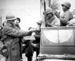 Two French soldiers giving African-American soldiers candy, Rouffach, France, 5 Feb 1945