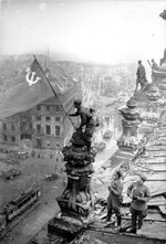 Red Army soldier Mikhail Alekseevich Yegorov of Soviet 756 Rifle Regiment flying the Soviet flag over the Reichstag, Berlin, Germany, 2 May 1945, photo 2 of 2; Meliton Kantaria and another watching nearby