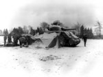 US 5th Armored Regiment tankers gathering around a fire and opening Christmas presents, near Eupen, Belgium, 30 Dec 1944; note M4 Sherman tank