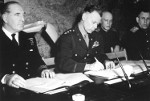 LtGen Bedell Smith signing the documents of Germany’s surrender, Reims, France, 7 May 1945. British Adm Harold Burrough is on the left. Soviet Gen Ivan Susloparov is on the extreme right.