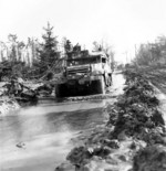 M3 Half-track vehicle of 16th Infantry Regiment, US 1st Infantry Division moving through a muddy road in the Hürtgen Forest, Germany, 15 Feb 1945