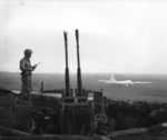 Overlooking Motoyama Airfield, Iwo Jima, Japan, 4 Mar 1945; note US Marine with M1 Carbine, Type 96 anti-aircraft mount, and the first B-29 to land on Iwo Jima