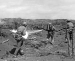 A US Marine used a flamethrower against a Japanese pillbox as he was covered by two riflemen, Iwo Jima, Feb 1945