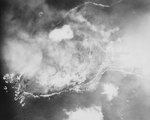 Smoke rising from Mount Suribachi as it was hit by aerial bombs and naval guns, 19 Feb 1945