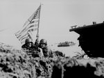 Two US officers plant the first American flag on Guam eight minutes after US Marines and Army assault troops landed on the beaches, 21 Jul 1944