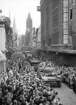 Daimler Armored Car and trucks passing through cheering crowds in Eindhoven, the Netherlands, 20 Sep 1944