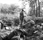 War correspondent Alan Wood, embedded with men of UK 1st Airborne Division, typing in woods near Arnhem, Gelderland, the Netherlands, 18 Sep 1944
