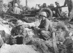 Weary US Marines taking a cigarette break, Namur, Kwajalein, Marshall Islands, early Feb 1944; note 37mm anti-tank gun and Browning M2 machine gun