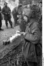 Italian and German troops eating a meal in the field, near Monte Cassino, Italy, 1943-1944
